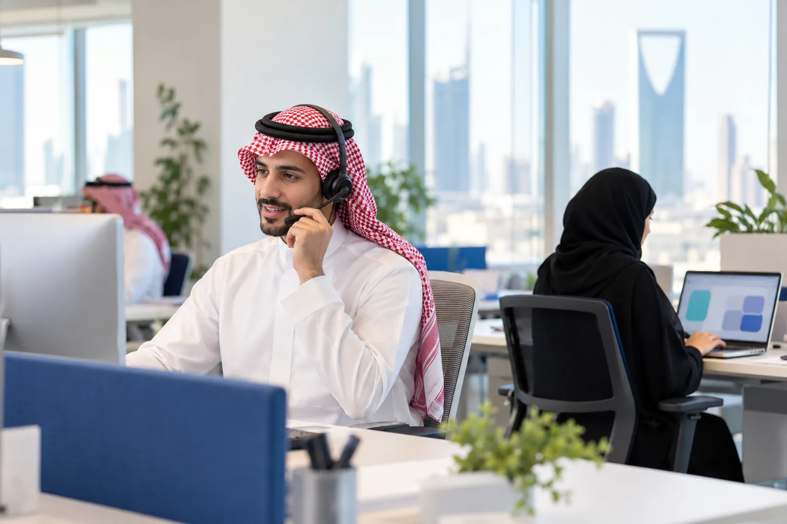موظف خدمة عملاء يستقبل شكوى هاتفياً وزميله يسجلها على الشاشة
