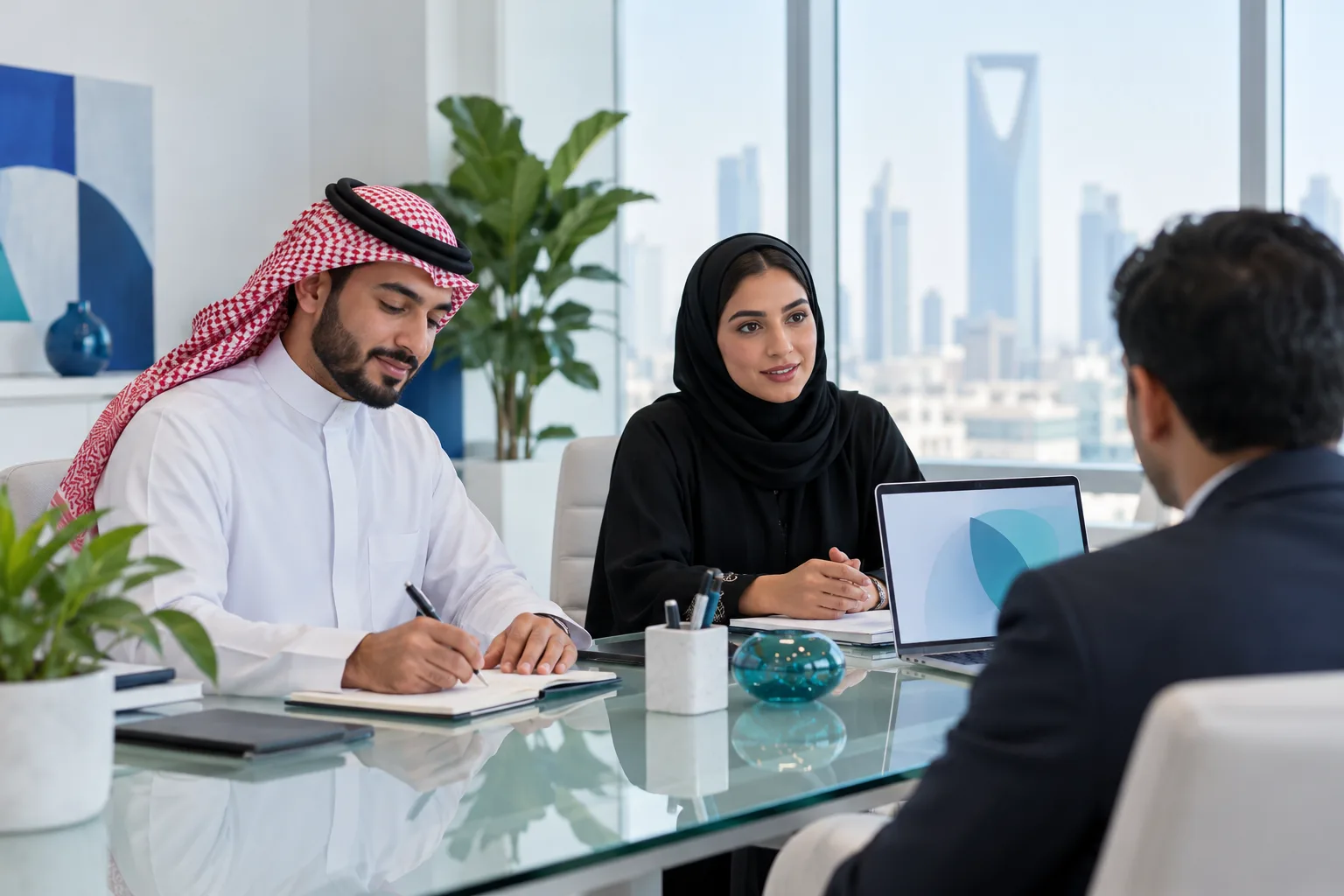 زميلان سعوديان يسجلان الملاحظات في اجتماع استكشاف مع عميل