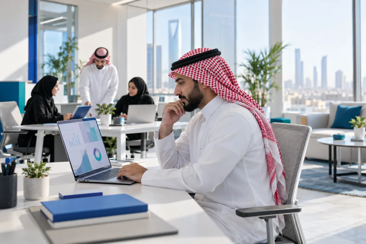 صاحب منشأة سعودي يراجع الفواتير وسجل المدفوعات على الحاسوب