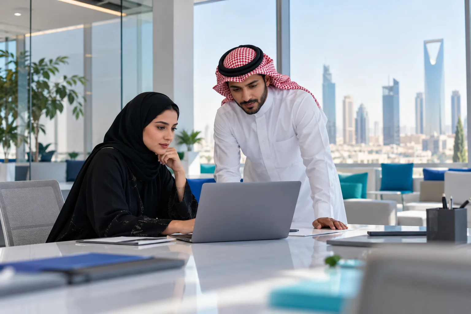 مدير مالي سعودي يراجع إعدادات الفوترة الإلكترونية على حاسوبه المحمول في مكتب مضيء